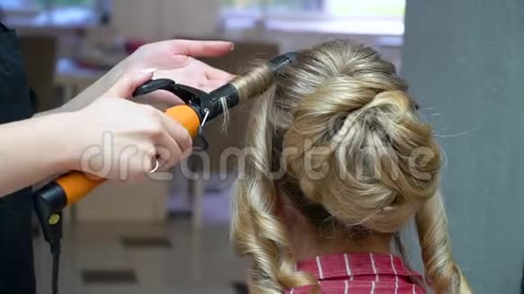 理发师在一头金发上做时髦的发型视频的预览图