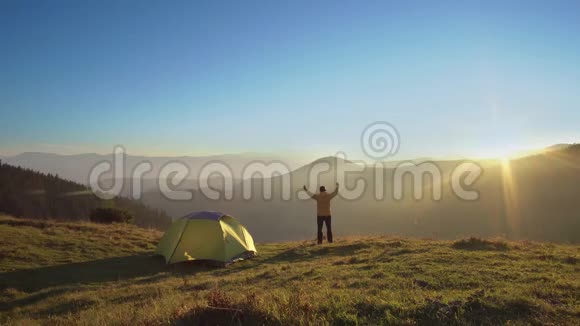一个人站在山上的帐篷附近视频的预览图