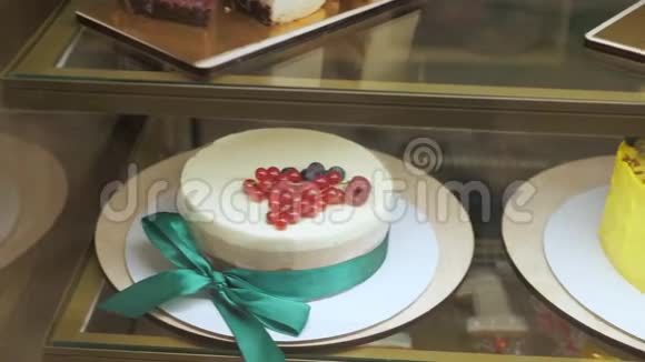 玻璃架子上有蛋糕和糕点的面包店视频的预览图