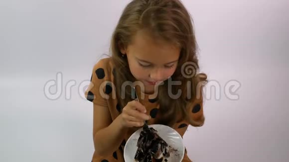 年轻女孩拿着一个盘子和一块巧克力蛋糕享受着味道视频的预览图
