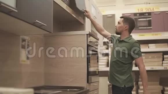 一个年轻人在商场里检查厨房架子他想买它视频的预览图