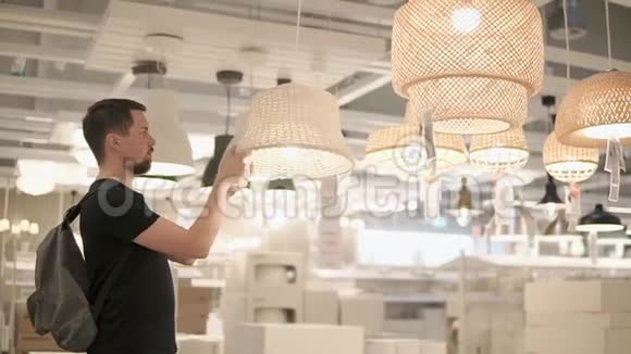 一位在购物店里的成年男性正在考虑灯具的落地灯视频的预览图