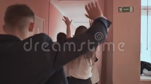 沿着走廊奔跑的高中生快乐组视频的预览图