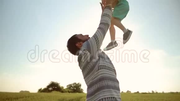 坚强的父亲在天空中游说儿子日落时分在麦田里和他玩视频的预览图