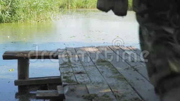 渔夫来到池塘边的木墩上坐在椅子上视频的预览图