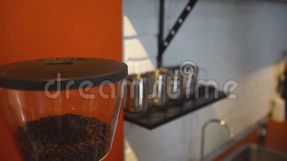 咖啡机中咖啡豆的特写艺术柜台后面配有带铁架子的专业咖啡师设备视频的预览图