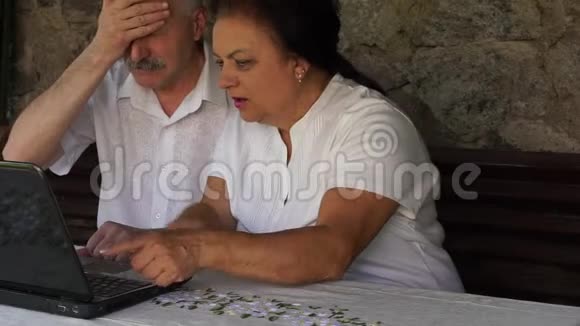 一对退休的老夫妇坐在一张有笔记本的长凳上视频的预览图