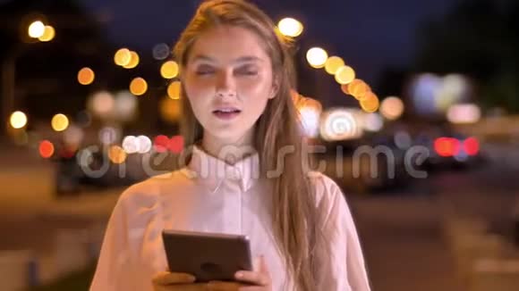 年轻可爱的女孩在夏天的晚上在她的平板电脑上打字思想观念沟通观念视频的预览图