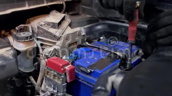 汽车服务粗壮的机修工把电池固定在车上视频的预览图