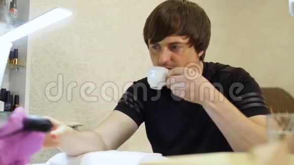 年轻人在修指甲的过程中放松和喝咖啡视频的预览图