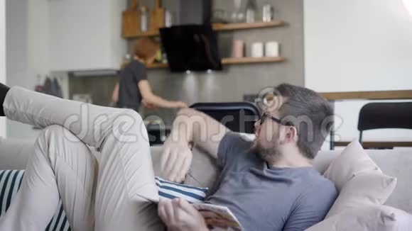 一个男人在客厅和他的烹饪妻子说话的近镜头视频的预览图