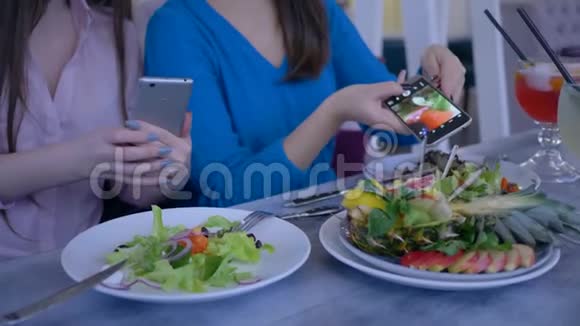 女性朋友的手在减肥期间健康的晚餐中使用手机拍摄美丽的沙拉视频的预览图