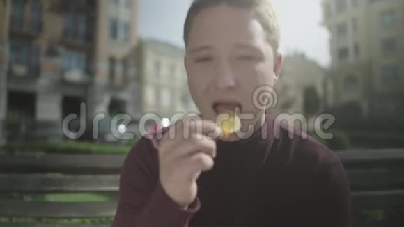 一个人坐在长凳上高兴地吃薯条视频的预览图