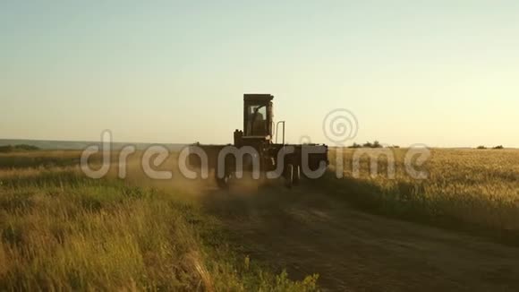 农夫骑着一辆旧车去上班联合收割机继续收割小麦旧的领地小麦田视频的预览图