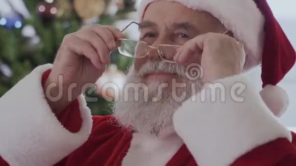 圣诞老人坐着笑着看一本有趣的书视频的预览图
