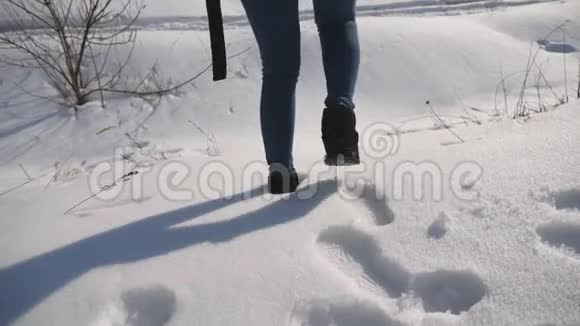 背着背包的小女孩正在雪地森林里散步女人在雪地上留下痕迹冬季景观慢慢视频的预览图