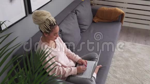 快乐的年轻自由职业者女人在舒适的沙发上工作视频的预览图