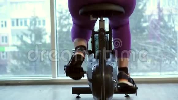 胖女人在健身自行车上剧烈运动视频的预览图