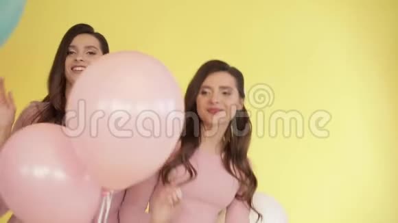 穿着粉色裙子玩彩色气球的漂亮双胞胎视频的预览图