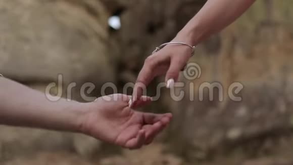 一个男人和一个女人在岩石的背景上牵手视频的预览图