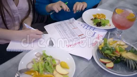 健康的生活方式女孩子在午餐时会把饮食计划的日历记在纸上视频的预览图