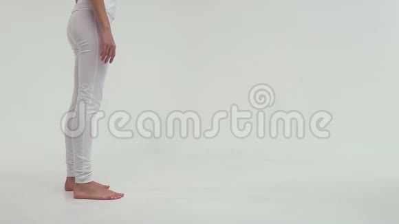 年轻迷人的运动女子在白色背景的运动垫上做侧桥视频的预览图