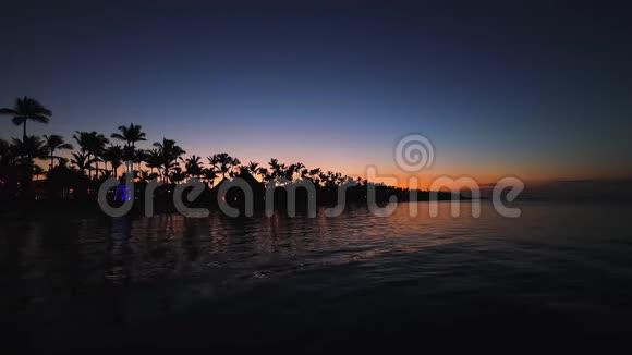 日落时的热带海滩浪漫的夜晚海水的灯光视频的预览图