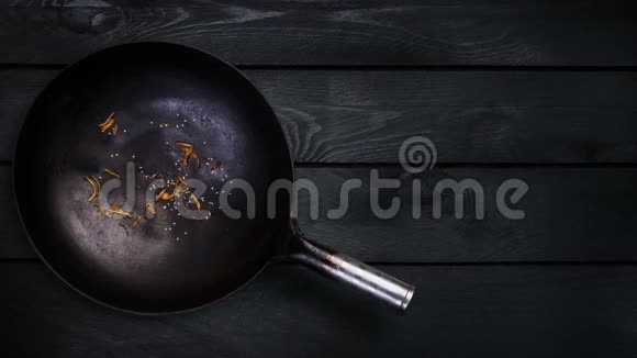 动画在黑色木制背景下煎锅中炒面锅的配料视频的预览图