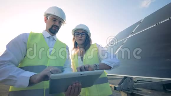 工程师在屋顶上工作站在太阳板附近视频的预览图