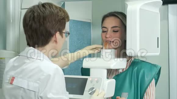有吸引力的年轻女孩用全景和头影X射线扫描仪检查牙齿视频的预览图