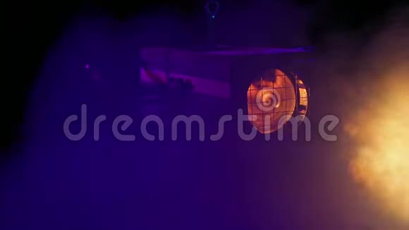 舞台上一阵烟雾中旋转的舞台轮廓聚光灯的致盲光束视频的预览图
