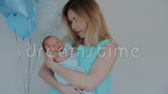 美丽健康的母亲抱着她新生的孩子亲吻宝宝视频的预览图