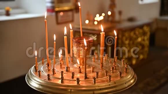 在空荡荡的东正教教堂的烛台上点燃蜡烛视频的预览图