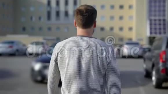 一个男人走在停车场坐在他的车里车是黑色的代表级视频的预览图
