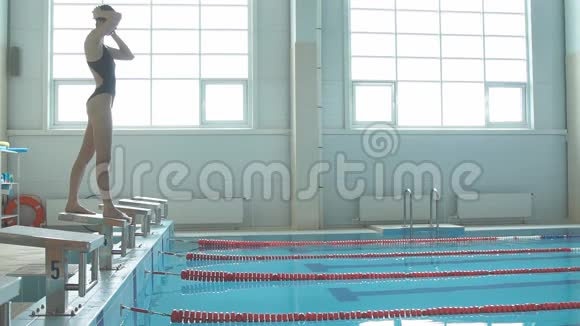 女游泳运动员跳下起点并开始游泳池高清慢动作视频职业运动员训练视频的预览图