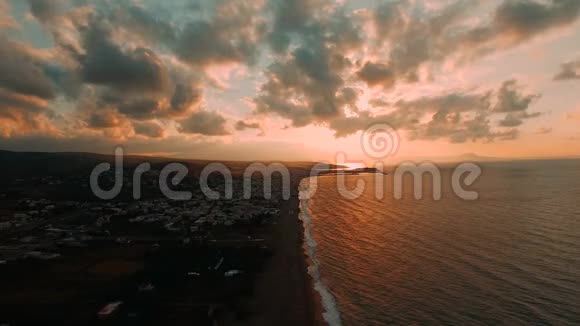 美丽的鸟瞰村庄旅游无人驾驶飞机沿着海岸拍摄日落希腊视频的预览图