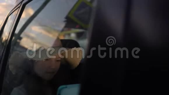 快乐的小女孩在汽车后座上驾驶电脑平板电脑公路旅行概念视频的预览图
