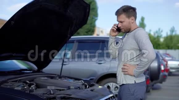 这个人正在叫汽车修理服务引擎盖打开了车子不会发动视频的预览图