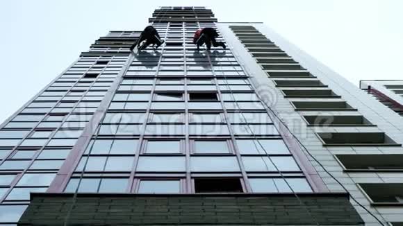 两个工业登山者正在清洗一座现代化办公楼的门面视频的预览图