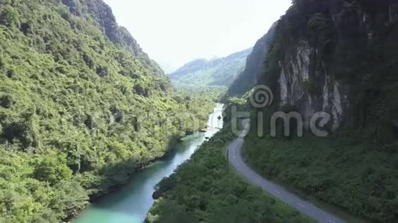 公路和河流蜿蜒于陡峭茂盛的河岸之间视频的预览图