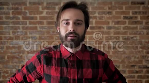 有胡子的年轻人正在挠你的头思考过程砖背景视频的预览图