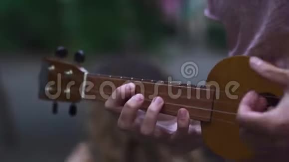 年轻女孩为她的伴侣演奏四弦琴视频的预览图