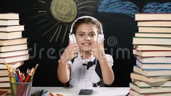 现代学校观念漂亮的女孩坐在一张桌子上手里拿着一堆书还有她身后的黑板积极积极积极视频的预览图
