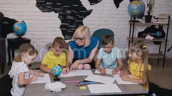 小学漂亮的孩子在教室里画画老师帮忙孩子们和老师一起画画视频的预览图