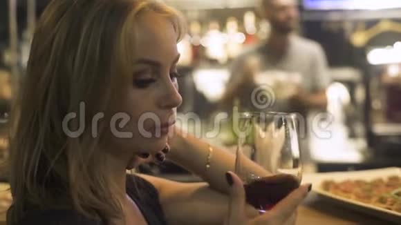 年轻女子手捧红酒杯在咖啡馆里在餐厅的活动派对上女人品尝和喝红酒视频的预览图
