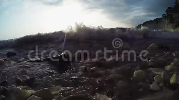 日落时的石质海滨岩石上的阳光灿烂视频的预览图