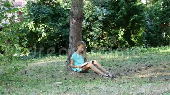 夏天在树下看书一个十几岁的女孩在户外看书视频的预览图