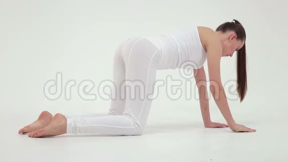 年轻迷人的运动女子在白色背景的运动垫上做侧桥视频的预览图