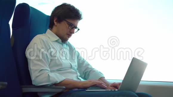年轻的经理骑着火车在他的笔记本电脑上工作视频的预览图