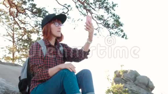 山顶上的女孩女游客在手机上用日出拍照视频的预览图